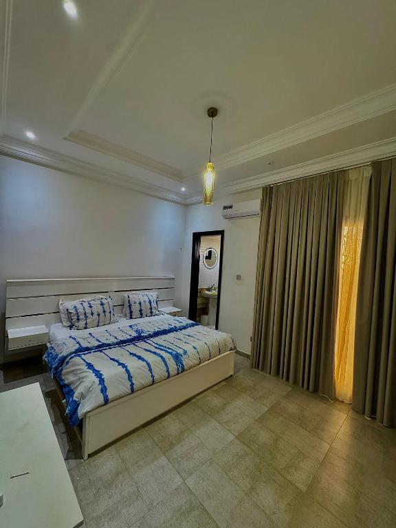 Chambre Deluxe avec couvre-lit à motifs indigo et rideaux donnant sur un balcon