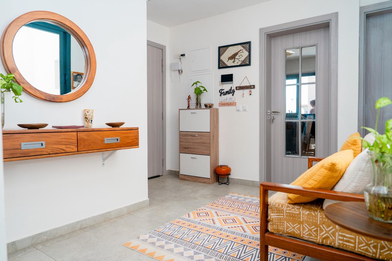 Entrée de l'appartement avec miroir rond et console en bois