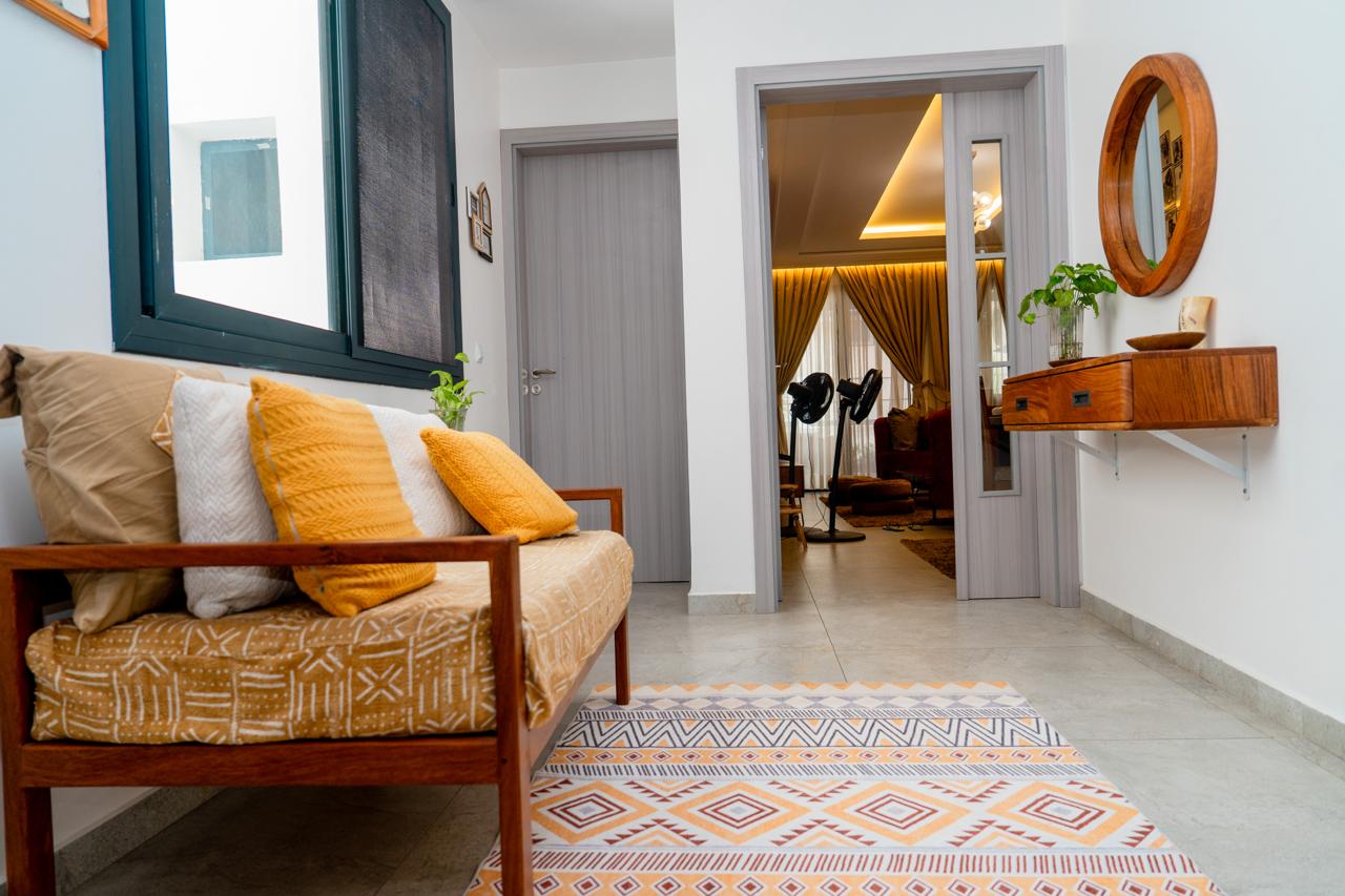 Entrée de l'appartement, banquette et tapis motif wax